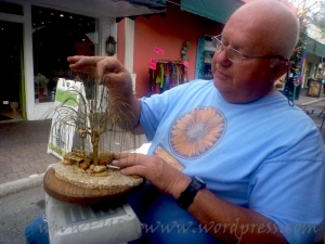 An artist forms wires into trees with his hands