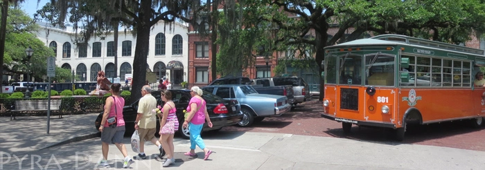 A trolley waits patiently for some tourists to pass by